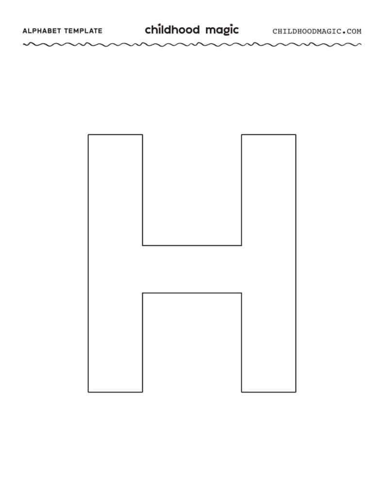 Close up of a young child holding a pencil correctly on a paper alphabet template.